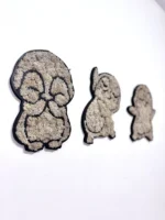 Three penguin silhouettes made of black outline and light moss side by side on a white wall.