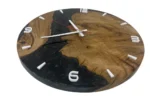 Wanduhr aus Eiche und schwarzem Epoxidharz mit weißen Ziffern und Zeigern in schräger Ansicht