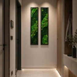 Two narrow, vertical moss wall art pieces with green moss and branches on a hallway wall with warm lighting
